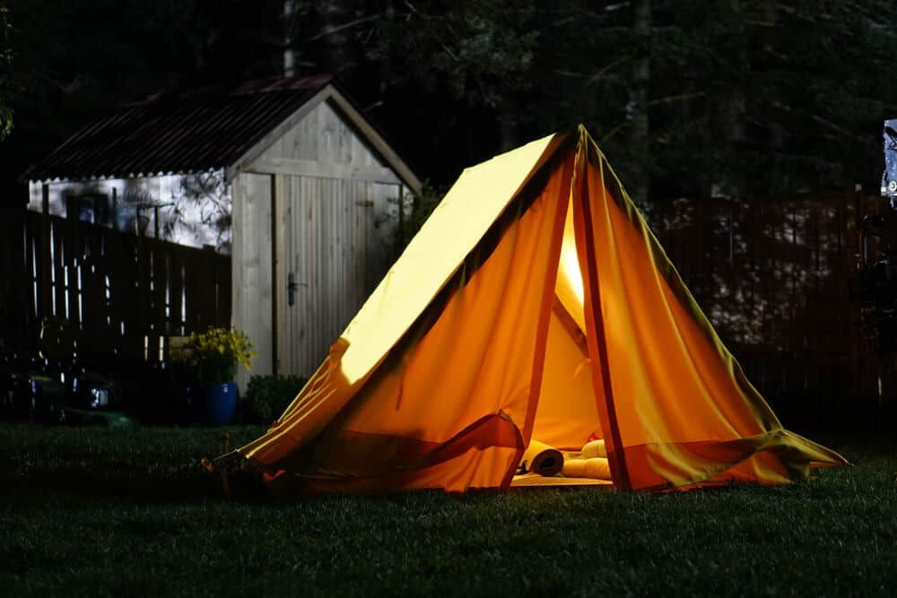 backyard camping with yellow tent at night