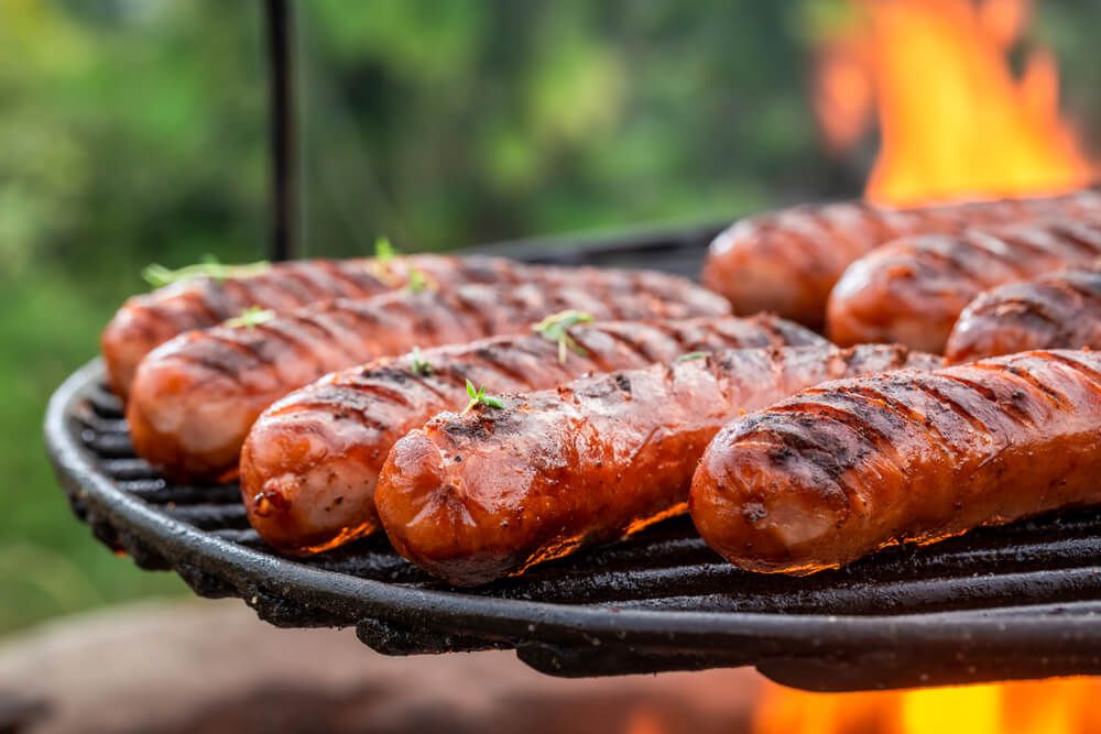 yummy bratwursts on bbq grill with fresh herbs