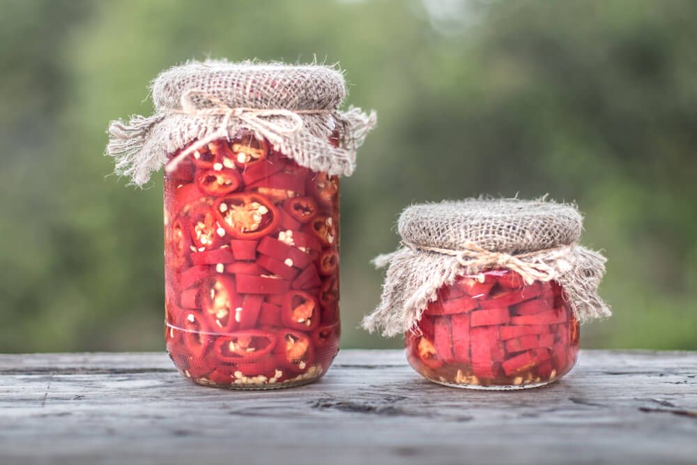 autumn red hot chili peppers marinating in glass jars