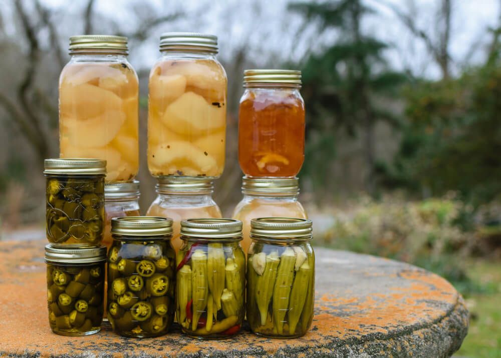 canned pears okra and jalapeno peppers on rustic table