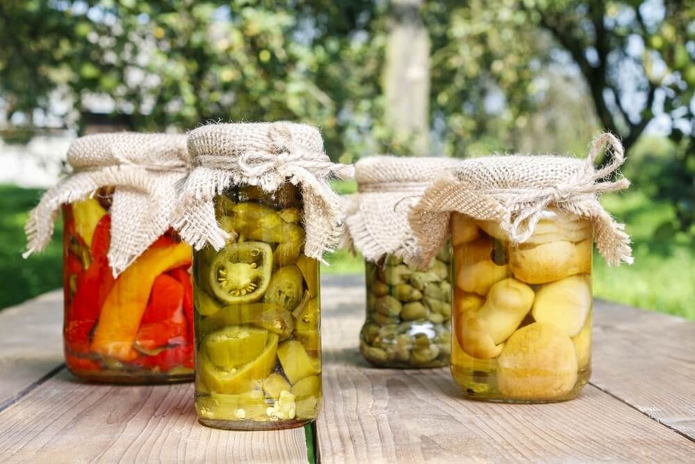 jars with preserves on rustic picnic table