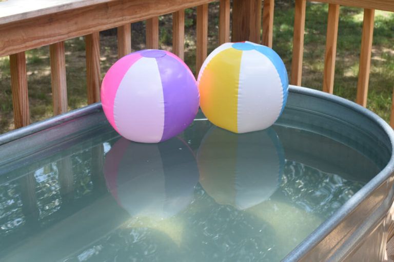 two colorful beach balls inside stock tank pool