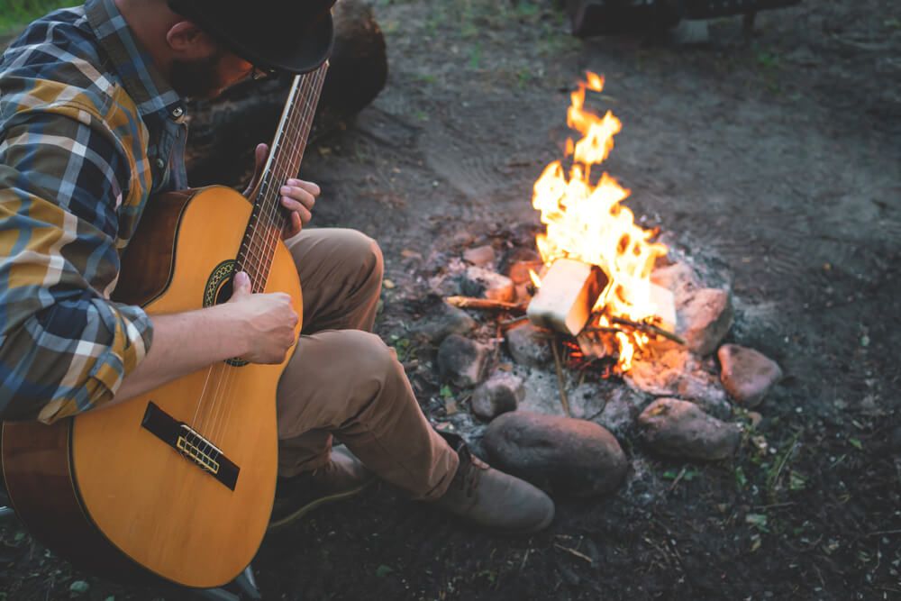 playing the guitar alongside fire in nature
