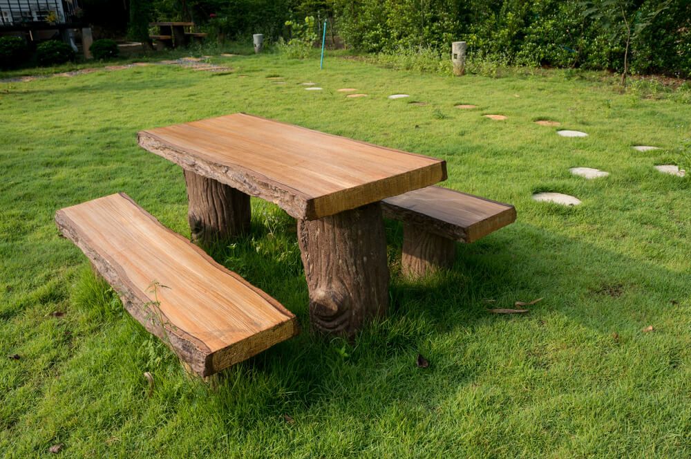 timber log picnic table on green grass