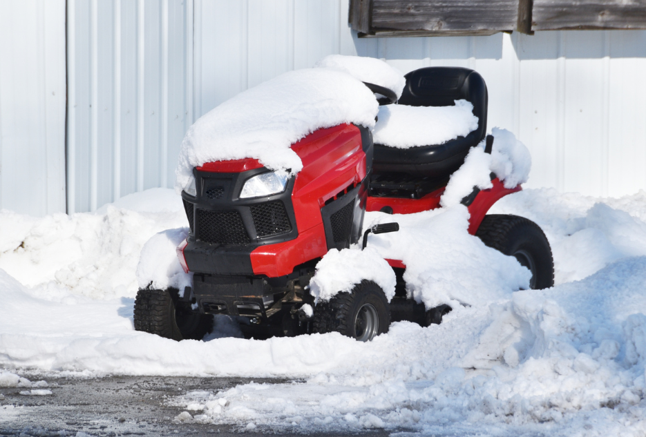 riding lawn mower covered in snow