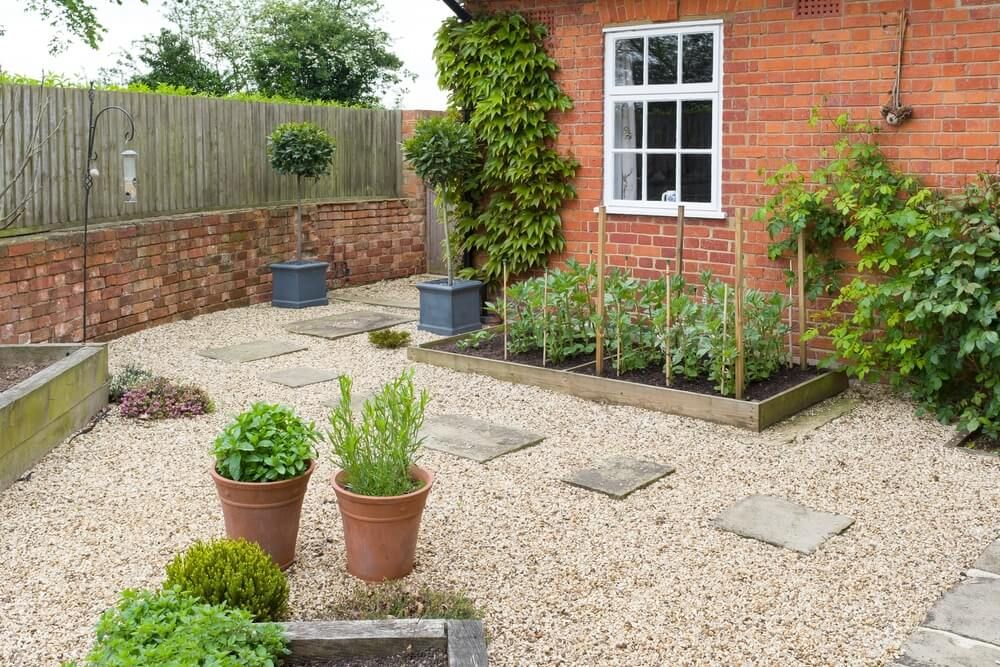 backyard garden with stepping stones gravel and raised garden beds
