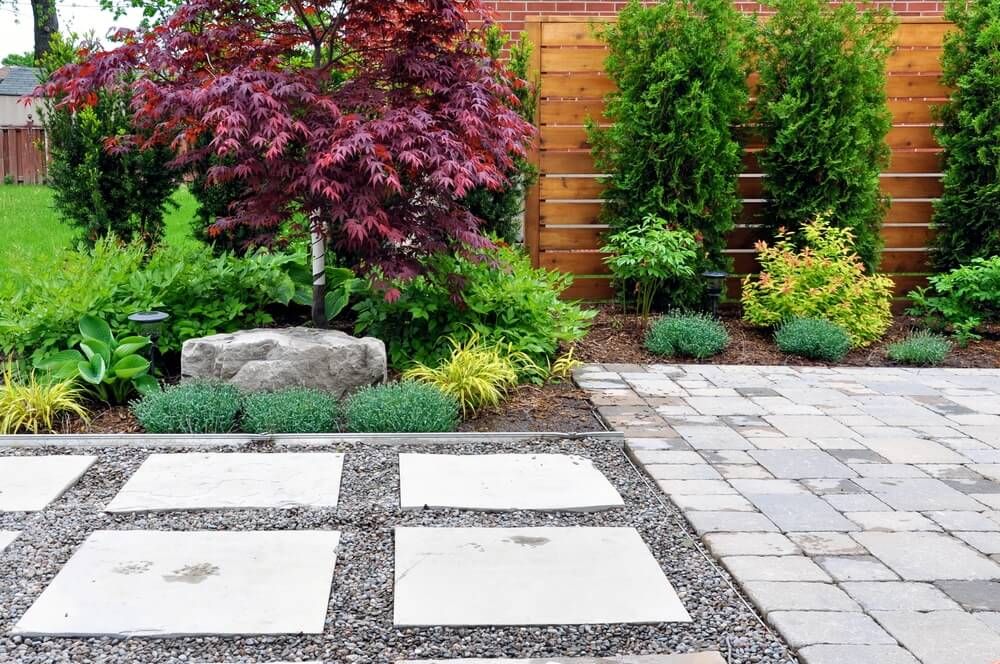 beautiful and neat garden with tumbled paver patio flagstones and cedar fence