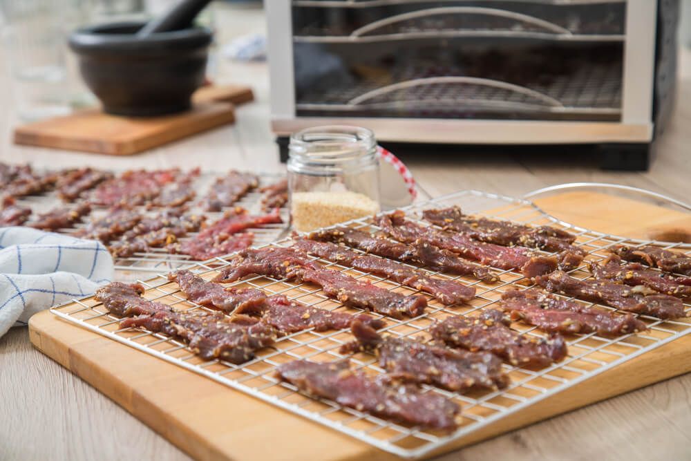 marinated beef strips yummy homemade jerky dried meat with chili and sesame on drying tray