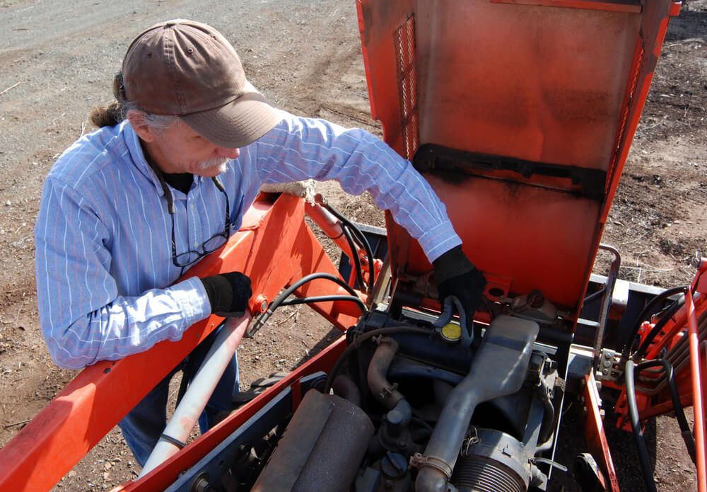 removing and checking the radiator cap on a garden tractor for annual maintenance