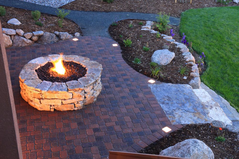 sleek backyard fire pit with fancy floodlit patio paver