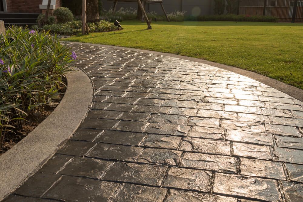 stamp concrete textured walkway with reflection from sunlight on the pavers