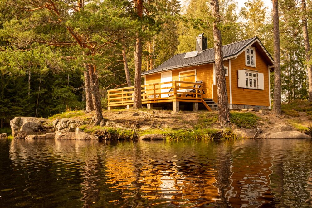 cabin in the woods next to a lake powered by solar energy