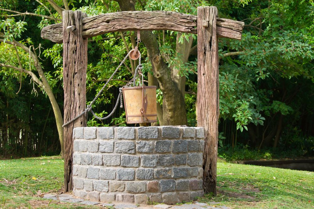 old stone water well with bucket and pulley system
