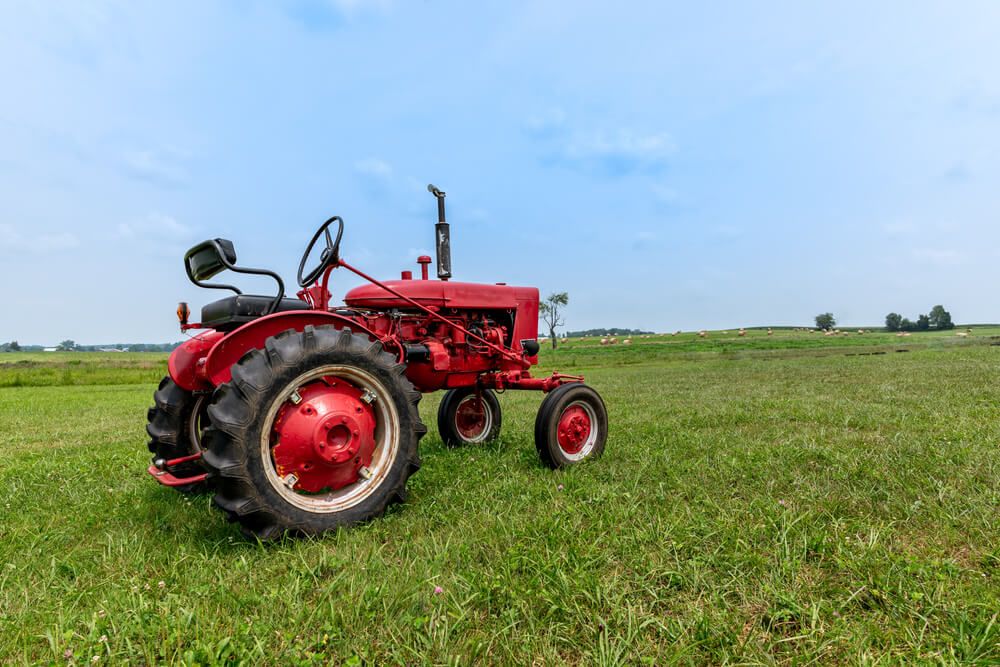 antique tractor in the field standing by ready to work