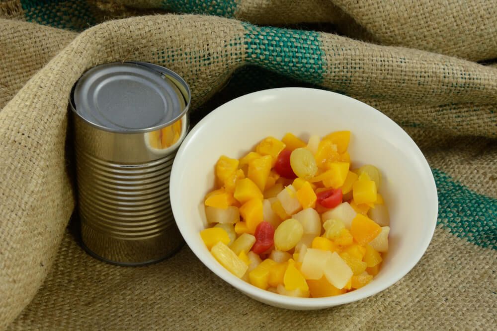 colorful fruit cocktail from the can resting on burlap cloth