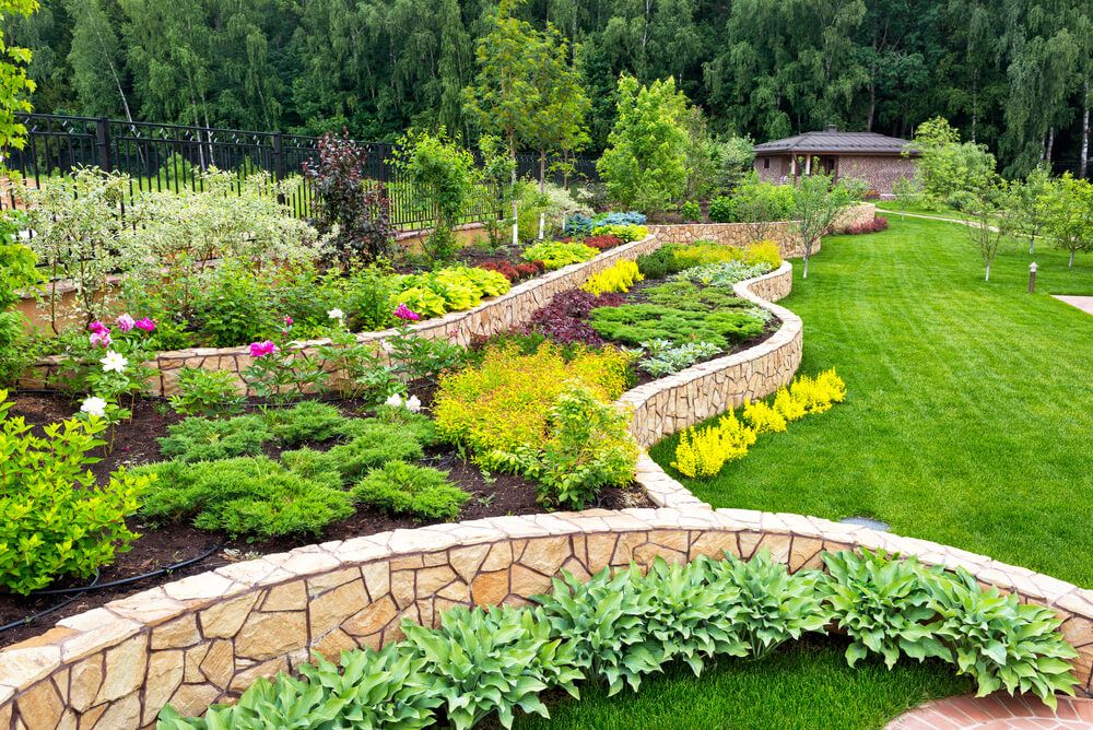 landscape design with beautiful backyard colorful shrubs flowers and fancy retaining walls