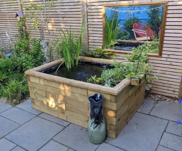 lovely raised garden bed with lush plants and cool water