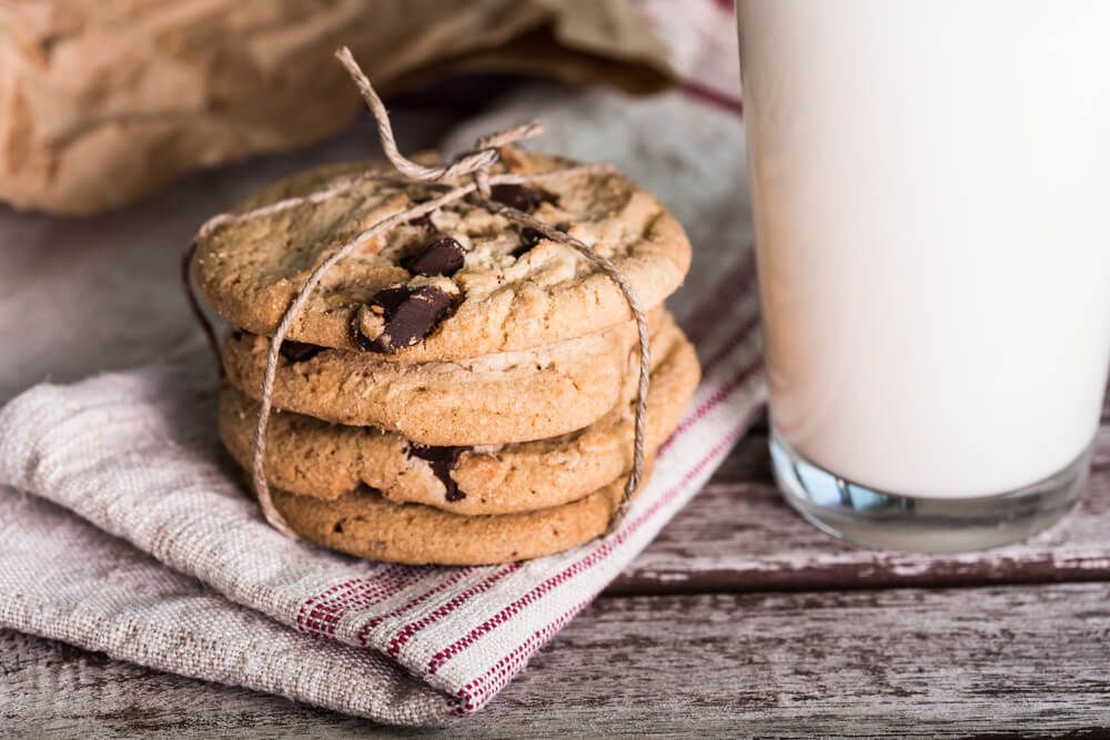 fresh homemade chocolate chip cookies with a tall glass of milk