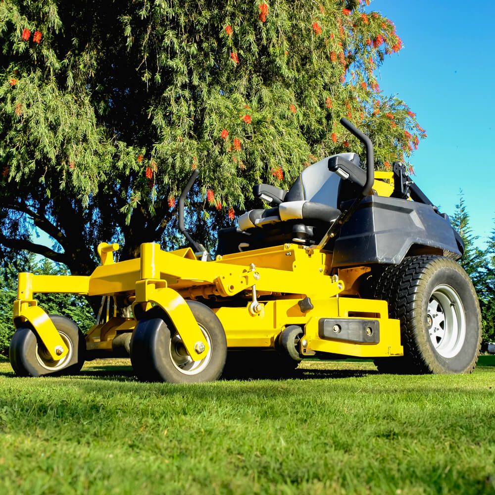 A lovely yellow zero turn mower on the grassy lawn prepared to cut some grass.