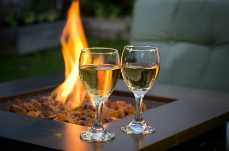Enjoying some white wine from the backyard bar alongside an outdoor fire.