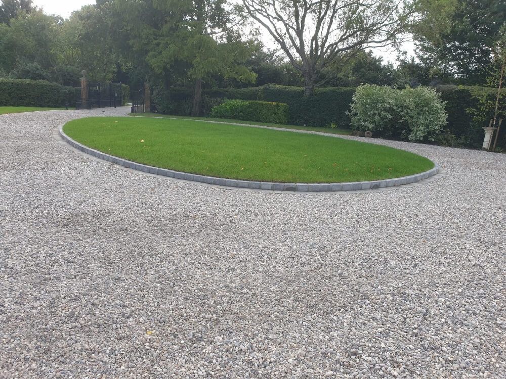 Lovely circular driveway design with sleek looking gravel.