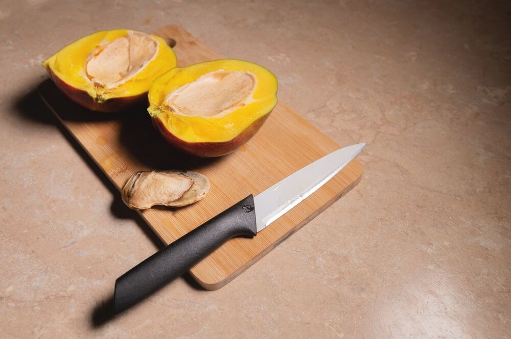 A yummy-looking kent mango cut in half with the mango seed removed.